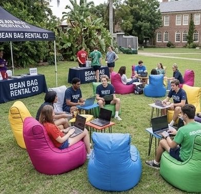 Students on Bean Bag Rental Co bean bags at a campus event with laptops and branded signage