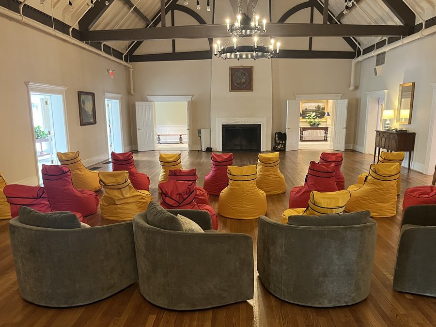 Wide view of a country club ballroom arranged with red and yellow bean bag chairs for a private event